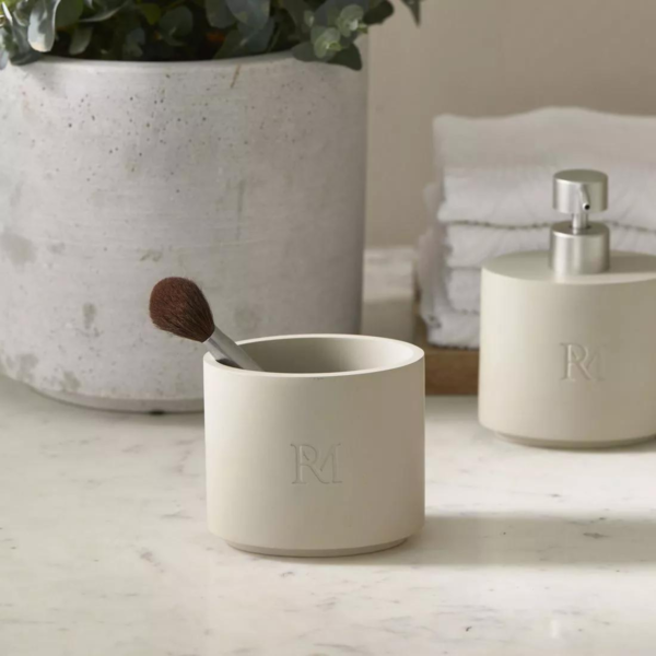 RM monogram toothbrush holder on a bathroom counter with a soap dispenser
